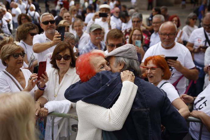 La periodista Rosa María Calaf y el cantante Joan Manuel Serrat durante la concentración de entidades y asociaciones con lectura del manifiesto 'Por un envejecimiento digno' por el Día Internacional de las Personas Mayores en la plaza de Sant Jaume