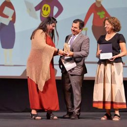 La directora de Cáritas Diocesana de Huelva, María Macías, recoge el premio.