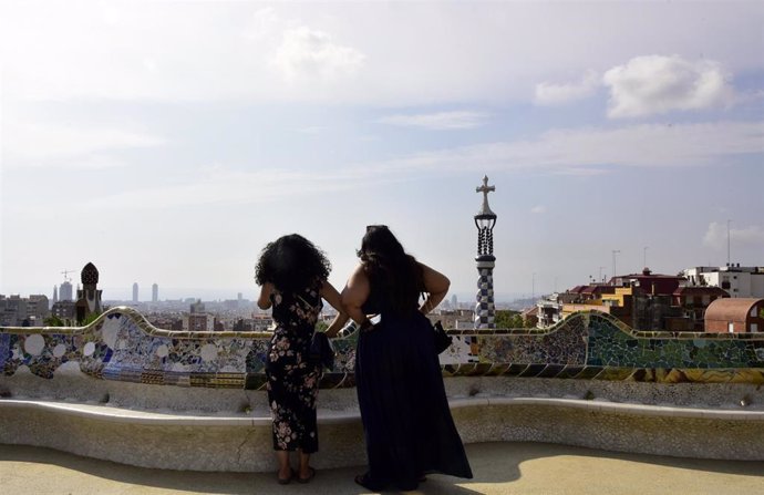 Archivo - Varias personas disfrutan en uno de los mosaicos de Gaudí ubicados en el Park Güell