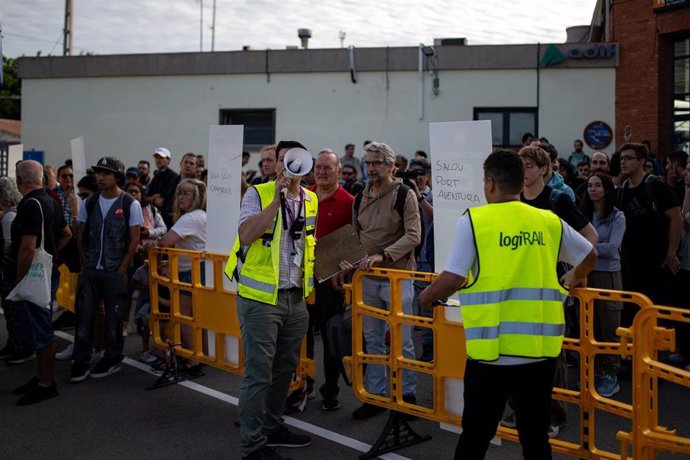 Afectados por el corte de Roda de Berà (Tarragona) esperan uno de los buses del servicio alternativo de Renfe.