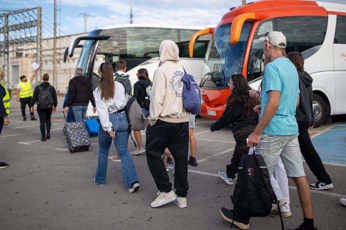 Afectados por el corte de Roda de Berà (Tarragona) esperan uno de los buses del servicio alternativo de Renfe.