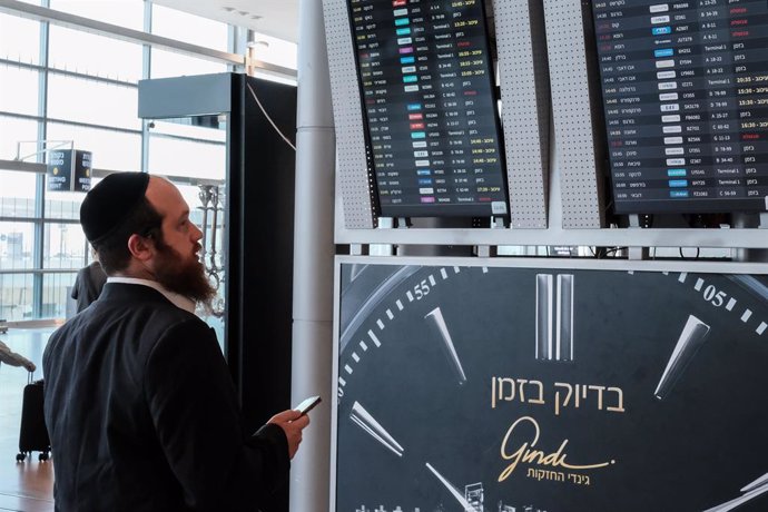 Archivo - August 4, 2024, Lod, Israel: Passengers check their flights on the departures board at Tel Aviv's Ben Gurion International Airport near Lod, showing numerous delays (yellow) and cancellations (red). Despite the peak travel season, the airport se