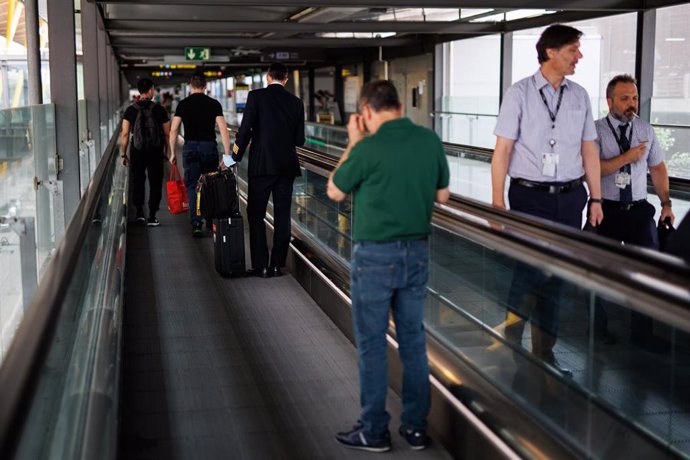 Archivo - Varias personas en las escaleras mecánicas de la Terminal 4 (T4) del aeropuerto Adolfo Suárez Madrid-Barajas.