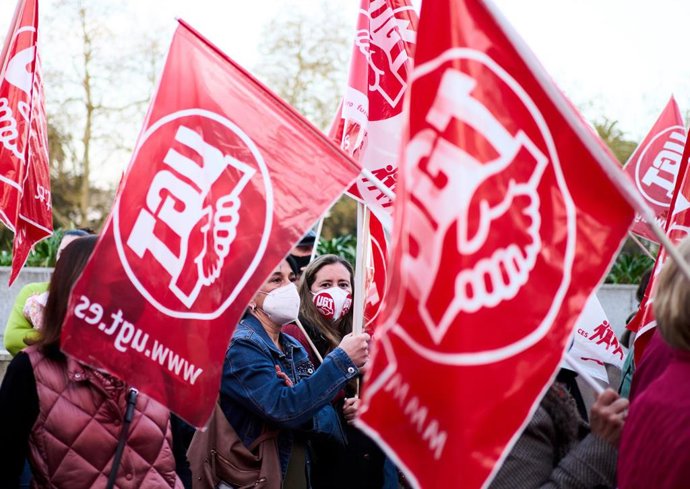 Archivo - Un grupo de personas sostiene banderines de UGT durante una concentración contra los altos precios de la energía eléctrica y la protección del empleo, frente a la Delegación del Gobierno de Santander