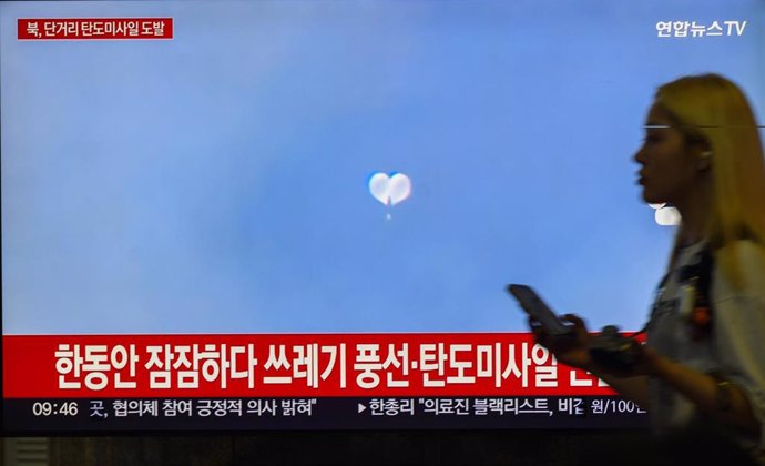 Una televisión emite imágenes de los globos con basura lanzados por Corea del Norte