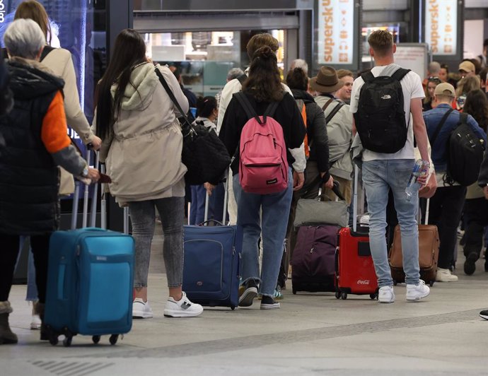 Archivo - Numerosas personas con maletas salen de viaje en la estación Almudena Grandes-Atocha 