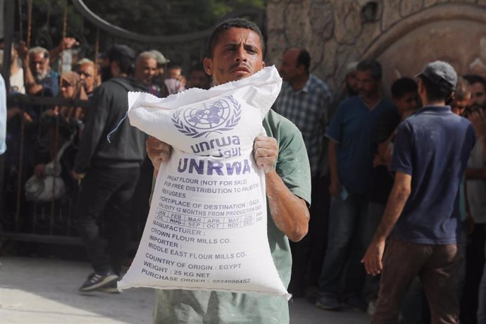 28 September 2024, Palestinian Territories, Deir al-Balah: Turkish Disaster and Emergency Management Presidency (AFAD) distribute flour to Palestinians in Gaza, where there is a food crisis due to Israeli attacks, at the United Nations Relief and Works Ag