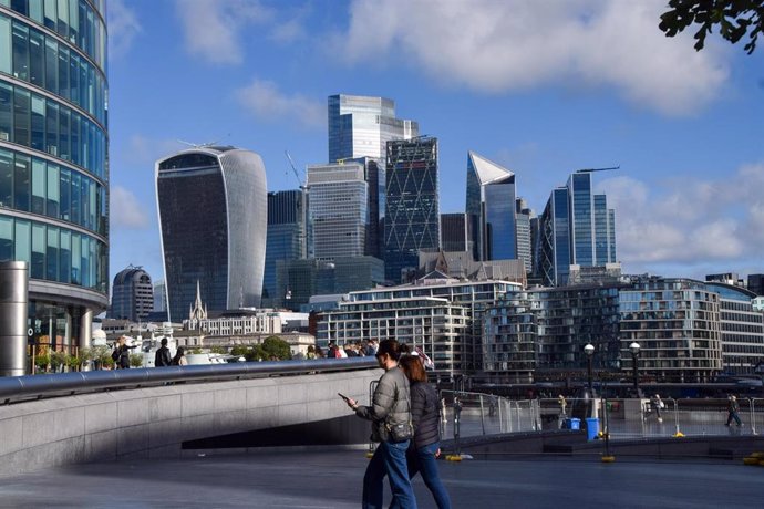 11 September 2024, United Kingdom, London: People walk near Tower Bridge past the City of London skyline, the capital's financial district.