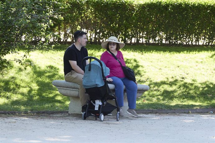 Archivo - Un hombre y una mujer con un carrito de bebé en el parque de El Retiro.