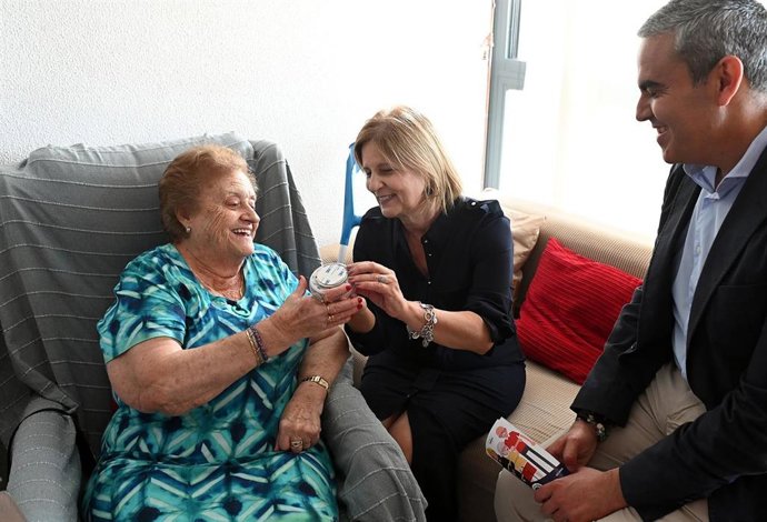 La alcaldesa de Jerez de la Frontera, María José García-Pelayo, y el presidente del Consorcio de Bomberos de la provincia de Cádiz, José Ortiz, junto a Antonia, a quien se le ha instalado un detector de humo en su vivienda.