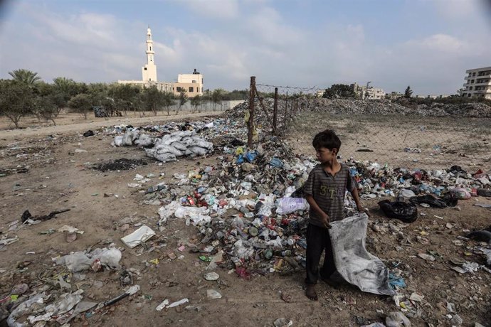 Archivo - Un niño palestino junto a una pila de basura en Deir al-Balah, Gaza.