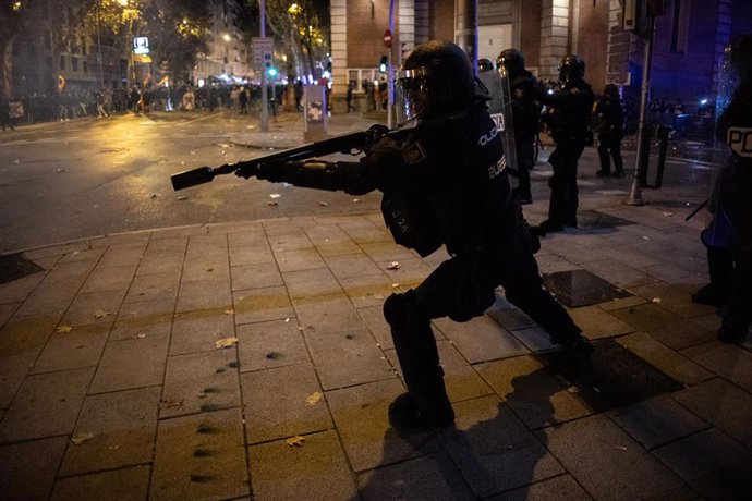 Archivo - Un agente de Policía dispara al suelo pelotas de goma contra un grupo de manifestantes, durante una protesta contra la amnistía