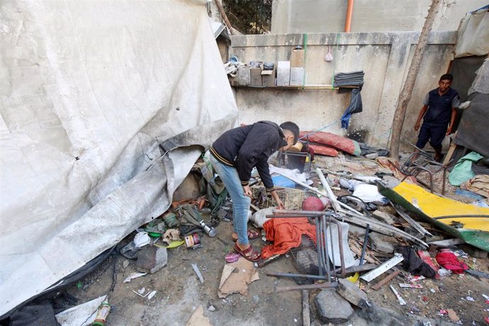 Civiles palestinos inspeccionan el lugar de un ataque sobre un campo de desplazados en la Franja de Gaza