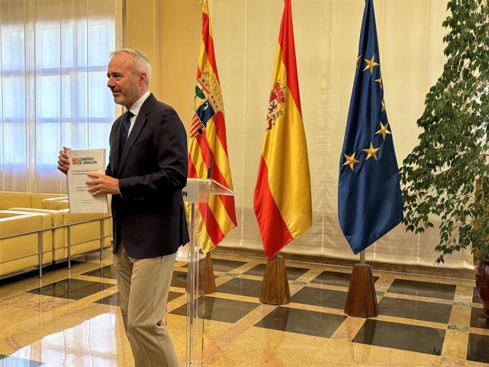 El presidente del Gobierno de Aragón, Jorge Azcón, muestra el documento de asuntos a debatir con el presidente del Gobierno de España, Pedro Sánchez, en la reunión en La Moncloa el 11 de octubre.