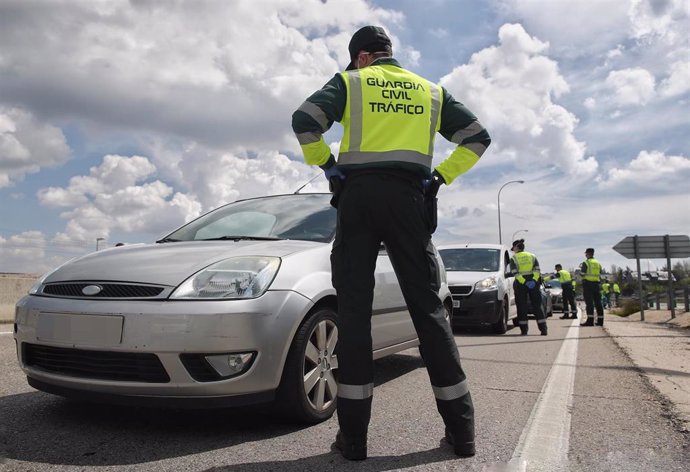 Archivo - Un guardia civil da el alto a un vehículo durante la pandemia