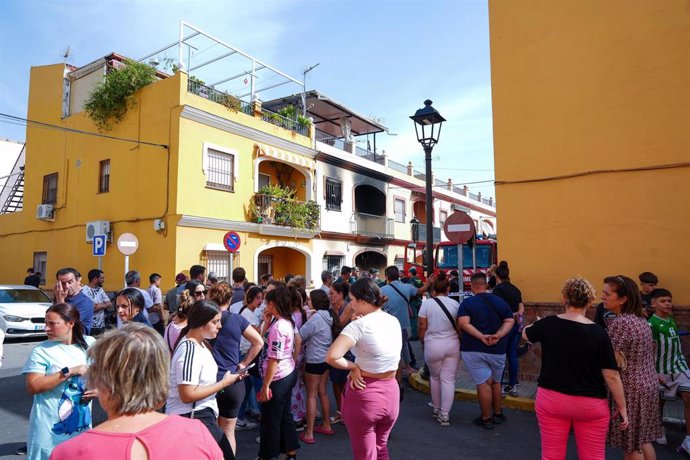 Vecinos se agolpan junto a la vivienda incendiada este domingo en Guillena (Sevilla). 