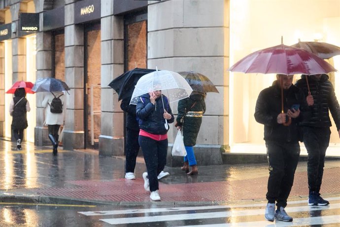 Archivo - Varias personas con paraguas un día de lluvia en Santander