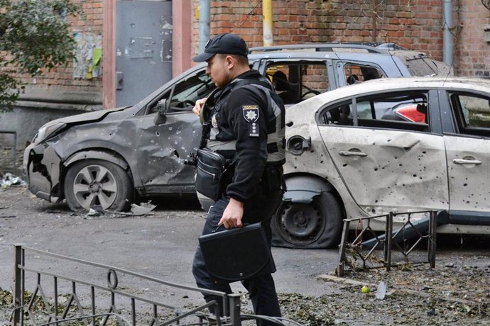 Un agente de Policía de Ucrania frente a un vehículo calcinado por una explosión