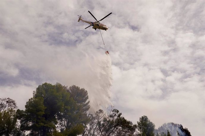 Un helicóptero  del Infoca arroja agua sobre el incendio declarado este lunes en el paraje denominado Leoncillo de Málaga capital.