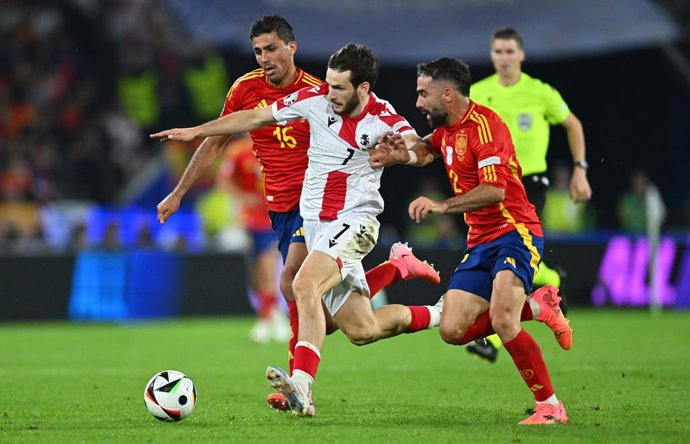 Archivo - 30 June 2024, North Rhine-Westphalia, Cologne: Georgia's Khvicha Kvaratskhelia (C) and Spain's Rodri (L) and Dani Carvajal battle for the ball during the UEFA EURO 2024 round of 16 soccer match between Spain and Georgia at the Cologne Stadium.