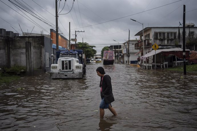 Archivo - 09 July 2024, Mexico, Veracruz: A woman walks across a flooded street after Hurricane Beryl passed through the region. Photo: Felix Marquez/dpa