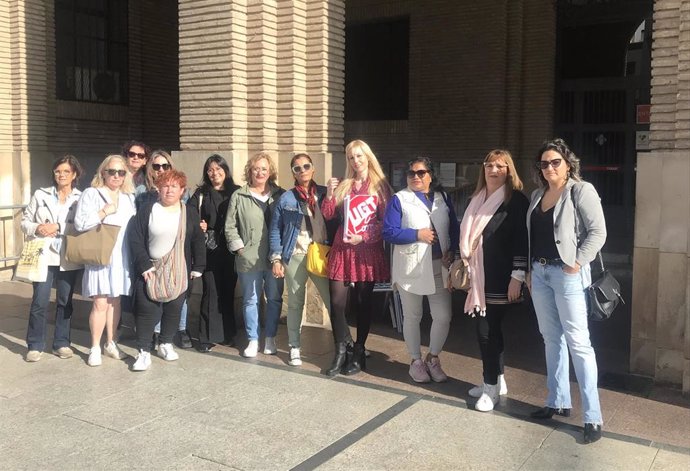 La secretaria del sector de servicios sociales en UGT Aragón, Angélica Mazo, junto a varias trabajadoras de ayuda a domicilio a las puertas del Ayuntamiento de Zaragoza