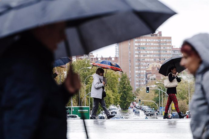 Archivo - Varias personas se protegen de la lluvia con paraguas, a 2 de noviembre de 2023, en Madrid (España). L