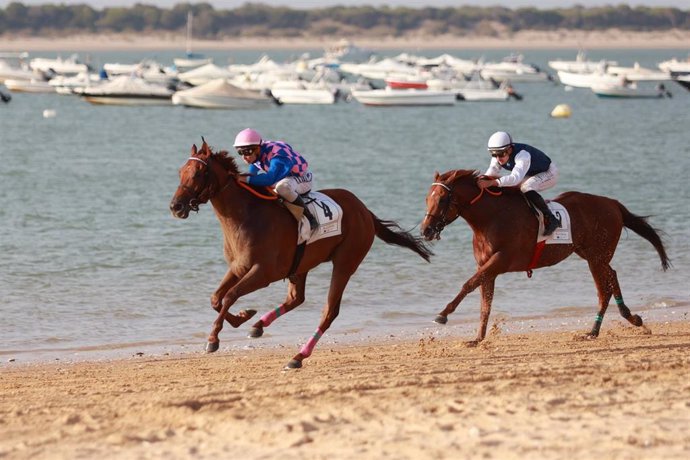 Archivo - Dos jinetes participantes en las Carreras de Caballos de Sanlúcar de Barrameda. A 28 de agosto de 2024, en Sanlúcar de Barrameda (Cádiz, Andalucía, España). 