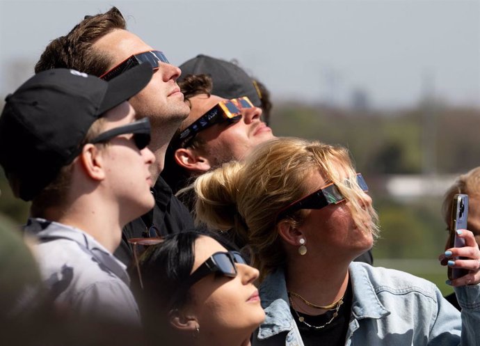 Archivo - 08 April 2024, US, Indianapolis: Spectators wearing protective glasses look toward the sun during a total solar eclipse viewing event at the Indianapolis Motor Speedway. Photo: Joel Kowsky/Nasa/Planet Pix via ZUMA Press Wire/dpa