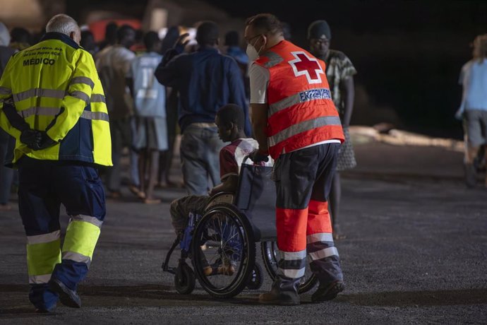 Un trabajador de la Cruz Roja atiende a uno de los migrantes que ha llegado al Puerto de La Restinga tras ser rescatados por la Guardamar Calliope