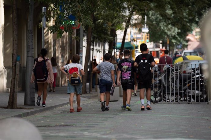 Archivo - Varios niños caminan a la salida del colegio en Barcelona