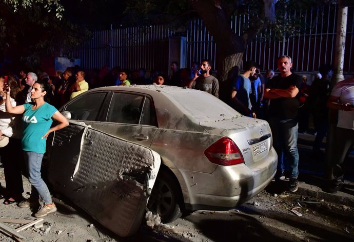 DAMASCUS, Oct. 8, 2024  -- People gather around a building damaged in an Israeli attack in the residential neighborhood of Mazzeh, west of Damascus, Syria, on Oct. 8, 2024. Seven people were killed and 11 others injured in an Israeli attack Tuesday night 