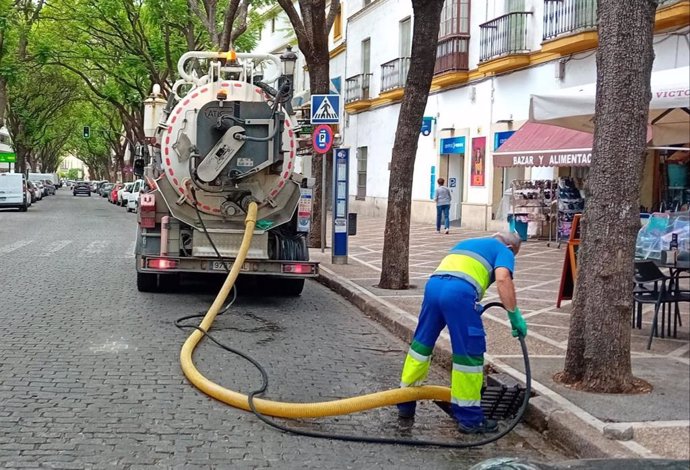 Un operario municipal limpia una alcantarilla en la calle Porvera de Jerez.