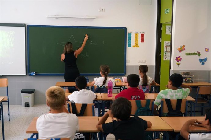 Una profesora enseña en un aula con alumnos.