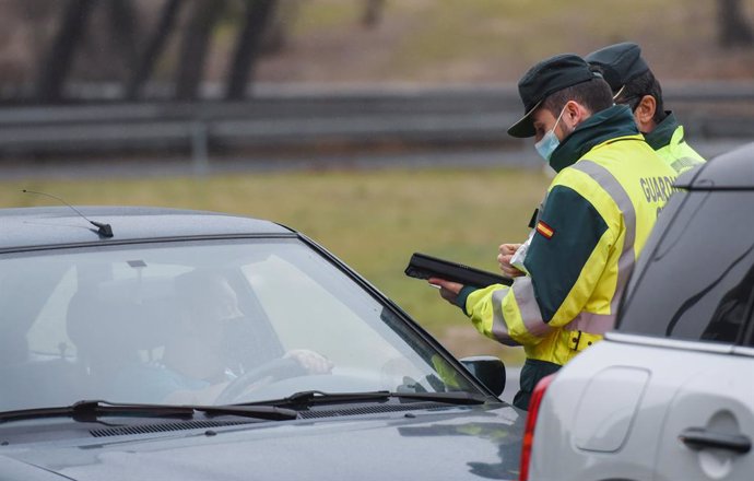 Archivo - Dos agentes de la Guardia Civil realizan un control de alcohol y drogas a un hombre en el kilómetri 13,600 de la carretera A-1, a 23 de diciembre de 2021, en Madrid (España). La DGT ha puesto en marcha la operación especial con motivo de las fie