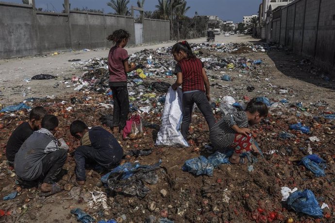 Archivo - Varios niños palestinos buscando entre la basura en el barrio de Deir al Balá, en Gaza. 