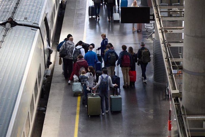 Archivo - Varias personas esperan a un tren en un andén.