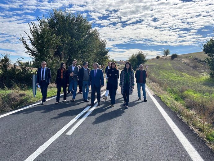 El consejero de Movilidad, Sanz Merino, acompañado por el alcalde de Urueñas, Javier Carpio, y otras autoridades regionales y provinciales, recorre parte del tramo de carretera intervenido.