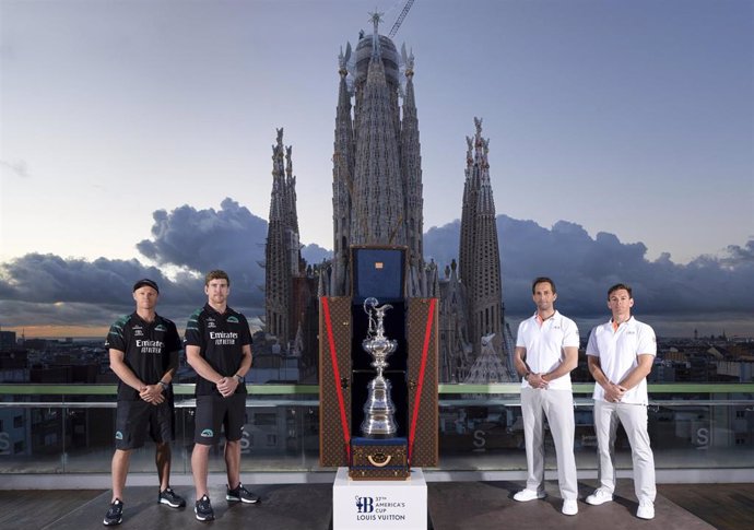 Peter Burling y Nathan Outteridge (izda) y Ben Ainslie y  Dylan Fletcher posan con el trofeo de ganador de la America's Cup con la Sagrada Familia de fondo