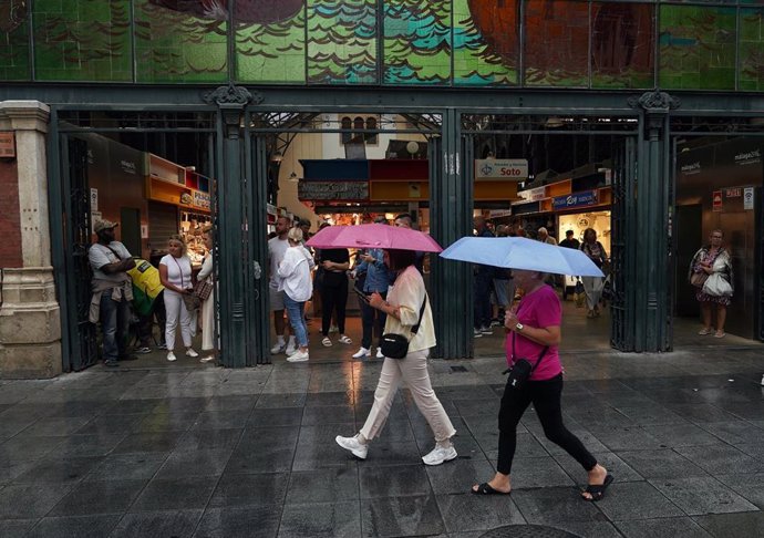 Transeuntes bajo sus paraguas durante la intensa lluvia.