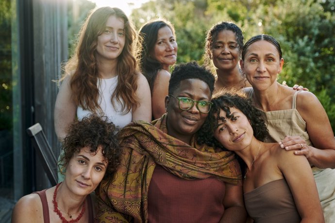 Archivo - Grupo sonriente de mujeres diversas sentadas en un patio