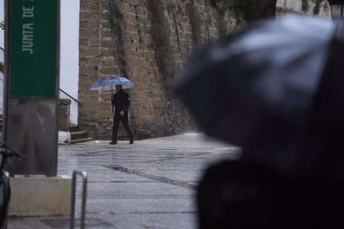 Transeuntes bajo sus paraguas durante la intensa lluvia. A 11 de octubre de 2024, en Cádiz (Andalucía, España). 