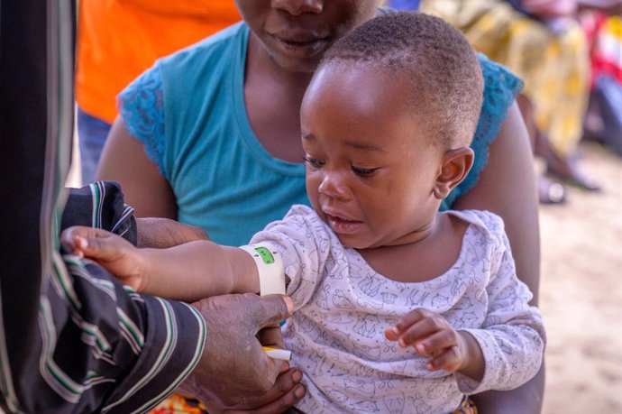 La partera Angela Zulu explica lo que está sucediendo en un puesto de salud a Kelvin y Jessica Beachum. Los bebés son pesados, examinados y vacunados en el puesto de salud del programa del área Chongwe Sur de World Vision.