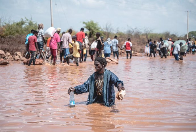 Archivo - MADOGO, Dec. 3, 2023  -- People wade through the road destroyed by floods at the Bangali-Garissa Road in Tana River County, Kenya on Dec. 1, 2023.   In the Mororo area at the border of Garissa and Tana River counties, eastern Kenya, residents ar