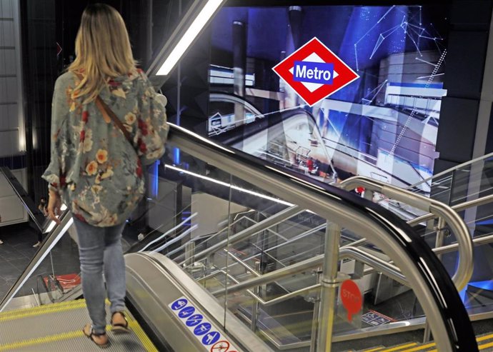 Archivo - Una mujer en la escalera mecánica en Metro de Madrid