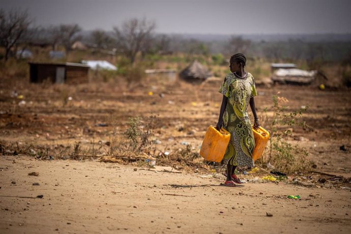 Archivo - Una mujer sursudanesa caminando con garrafas de agua