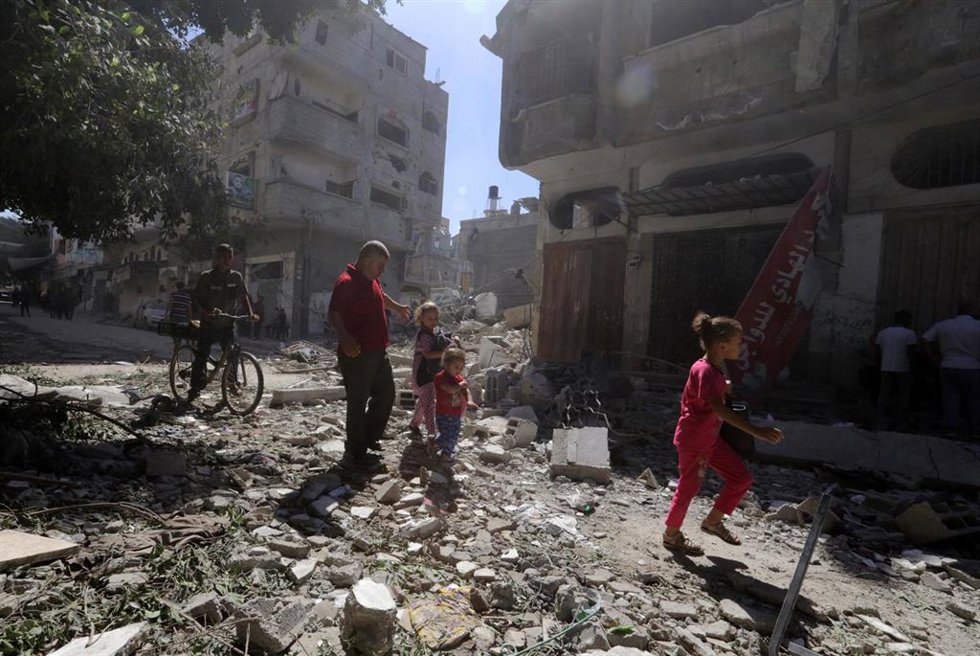 Palestinos frente a edificios destruidos por los ataques ejecutados por el Ejército de Israel contra el campamento de refugiados de Bureij, en el centro de la Franja de Gaza (archivo)