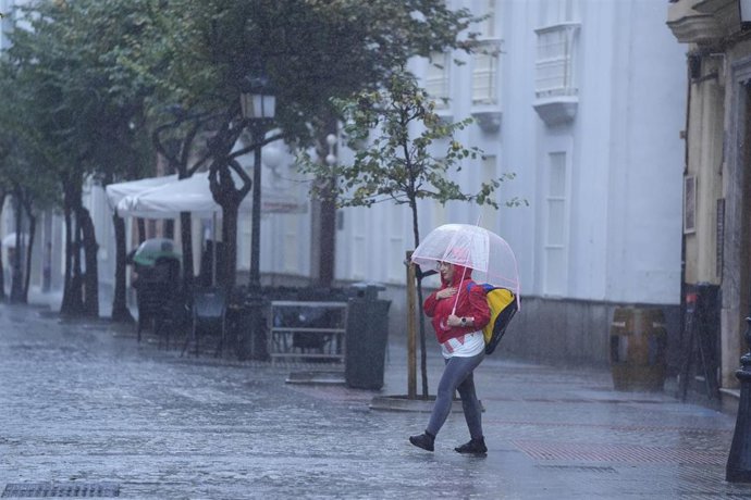 Transeuntes bajo sus paraguas durante la intensa lluvia. A 11 de octubre de 2024, en Cádiz (Andalucía, España). 