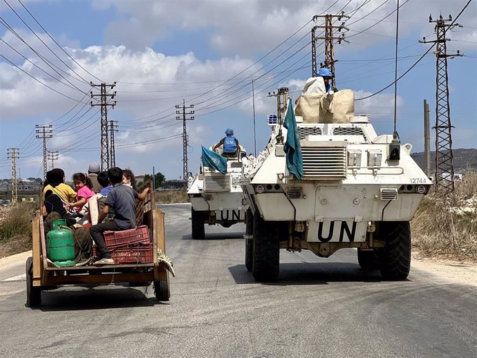 Ciudadanos libaneses desplazados de sus hogares en la carretera junto a vehículos blindados de la Fuerza Interina de Naciones Unidas en Líbano (FINUL)