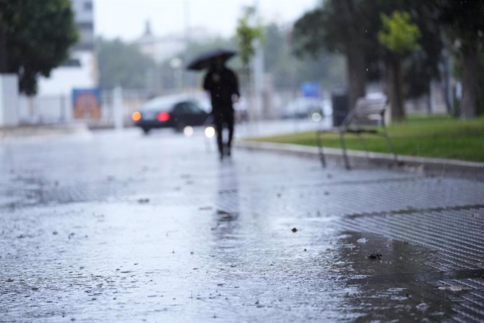 Transeuntes bajo sus paraguas durante la intensa lluvia. A 11 de octubre de 2024, en Cádiz (Andalucía, España).